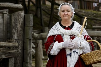 A female performer in traditional costume holds a basket and smiles, Ballarat, Australia