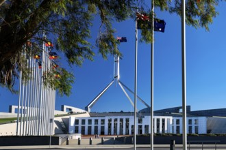 The Parliament House in Canberra, surrounded by flags and bright blue skies, Canberra, Australian