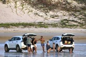 Beach visitors stand next to cars on the sandy beach of Cable Beach, Broome, Broome, Western