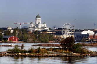 A view of Helsinki with cathedral and Ferris wheel behind an island offers a fascinating panorama,