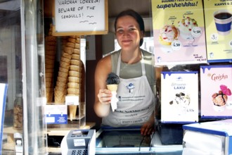 Saleswoman presents salmiac ice cream at an ice cream stand at Senaatintori, Helsinki,