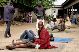 Patients sitting on mats outside in men's psychiatric ward, Bouaké, Nimbo, Côte d'Ivoire