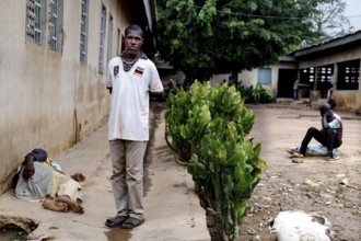 A patient stands outside a men's psychiatry building, Bouaké, Nimbo, Côte d'Ivoire