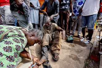 A homeless person is supported by people on the street, CI Bouaké, Ivory Coast