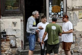 Group of men talking friendly in front of an old building in Uzupis, Vilnius, Vilnius County,