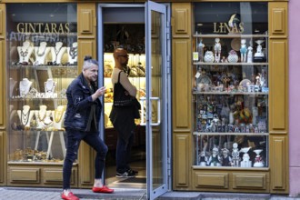 Passers-by enter the jewelry shop on a busy street with a golden façade, Vilnius, Vilnius County,