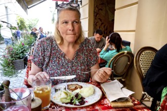 A woman enjoying a meal at Etno Dvaras restaurant in Vilnius on a summer day, Vilnius, Vilnius