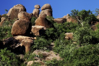 Large rock formations with surrounding vegetation under a clear sky, Babile, Oromia, Ethiopia