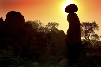 Silhouettes of rocks and trees during a spectacular sunrise in the Valley of Wonders, Babile,