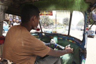 Driver drives a Bajaj taxi in busy city traffic, Bahirdar, Ethiopia