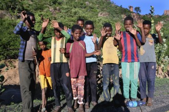 Young group in cheerful mood in front of a hilly landscape, Babile, Ethiopia