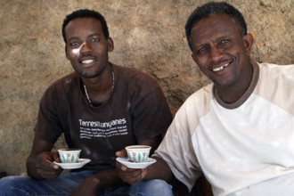 Bezhabe and Kusay take part in a relaxed coffee ceremony in Axum and hold coffee cups, Axum,
