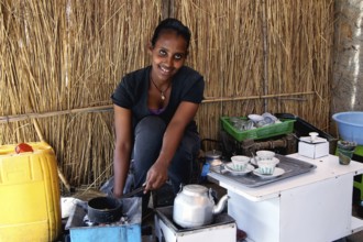 Woman prepares freshly brewed coffee as part of a traditional coffee ceremony in Axum, Axum,