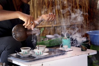 Traditional coffee ceremony with steaming coffee and cups, Axum, Ethiopia