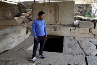 Guide Raphael shows ancient ruins in Axum's Stelenpark, known as Tomb of the False Door, Axum,