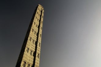 A tall, impressive stele rises majestically against the clear sky, Axum, Tigray, Ethiopia