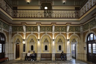 Elegant interior view of Dunedin train station with people on wooden benches, Dunedin, null, New