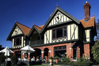 Historic Tudor style building with red bricks under blue sky in Mona Vale, Christchurch, Mona Vale,