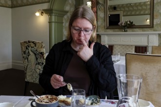 Woman enjoying high tea in elegant setting in Mona Vale, Christchurch, Canterbury, New Zealand