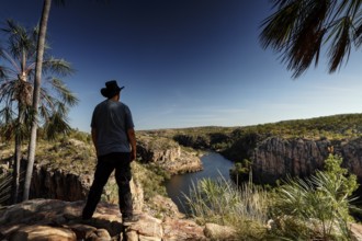 Person standing at a lookout overlooking the river and rocky landscape at Pat's Lookout, Katherine