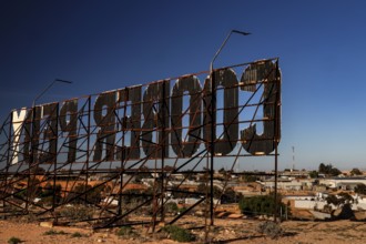 Metal structure sign in Coober Pedy shows the city name in a desert setting, Coober Pedy, South