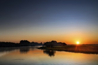 A clear sunrise is reflected in the water in Kakadu National Park, Kakadu National Park, Northern