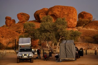 Campground in the evening surrounded by impressive red rock formations, Devil's Marbles, Northern