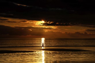 Golden sunset on Cable Beach with heavenly reflections in water, Broome, Western Australia,