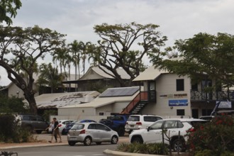 Building with parked cars and trees on Carnarvon Street, Broome, Western Australia, Australia