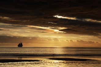 Spectacular sunset with sailboat on horizon over Cable Beach, Broome, Western Australia, Australia