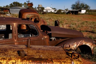 Rusty junk car in the barren landscape of Old Andado Station, Old Andado Station, Australia