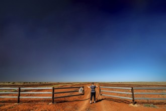 Gate on the Old Andado Track in the red sands of the desert under wide skies