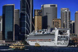 Large cruise ship in harbor in front of the impressive skyline of Sydney, Sydney, New South Wales,