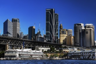 Sydney's Walsh Bay with impressive skyline and distinctive bridge over sparkling water, Sydney, New