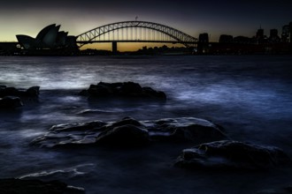 Silhouette of Sydney Opera House and Harbour Bridge at dusk, Sydney, New South Wales, Australia