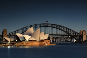 Illuminated opera house and harbour bridge in front of the night skyline of Sydney, Sydney, New