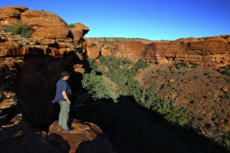 Person standing at the edge of Kings Canyon with deep views of the valley, Watarrka National Park,