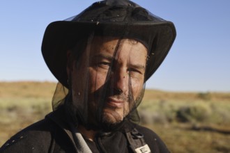 Man with fly net on Old Andado Track in sunny surroundings