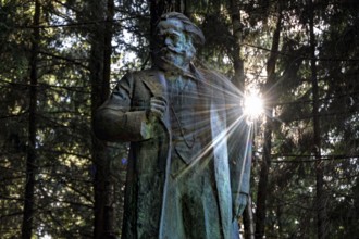 Marx monument in the sunlit forest of Grutas Park in Druskininkai, Druskininkai, Lithuania