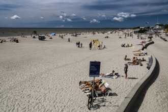 Long, extensive beach with sun beds and walkers under a blue sky, Pärnu, Pärnu County, Estonia