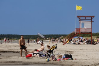 Busy beach with lifeguard tower and lots of bathers under a blue sky, Pärnu, Pärnu County, Estonia