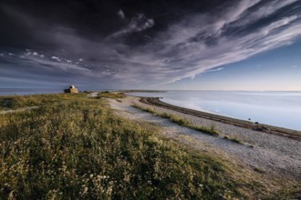 Tranquil stretch of coast with dramatic skies and soft grass, Särve, Saaremaa, Estonia