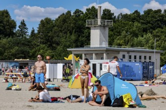 Beach life with tents and a large building in the background in sunny weather, Pärnu, Pärnu County,