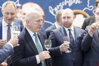 Kai Wegner (Governing Mayor of Berlin) with a glass of wine in his hand at Ukraine's stand during
