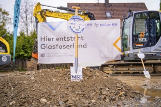 Construction site for fibre-optic expansion with excavators and signs in the background, fiberglass
