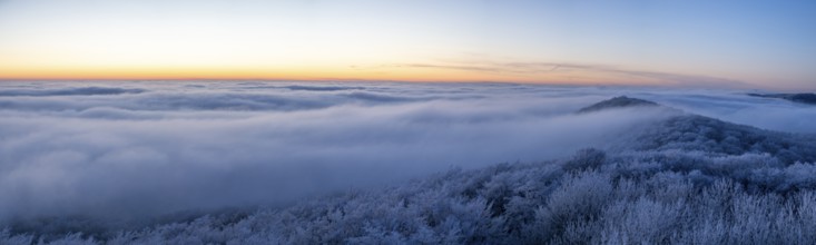 Wide, snowy landscape under a calm sky at dusk, panoramic view of the Teutoburg Forest from an
