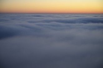 Soft morning clouds in pastel colors over a calm horizon in the Teutoburg Forest, Steinegge
