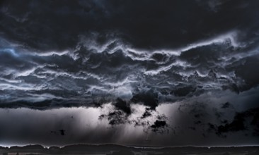 Threatening storm clouds criss-cross the dark sky, Osnabrücker Land, Wiehen Mountains, Lower