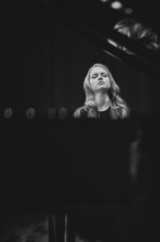 Young woman, pianist, with concentrated facial expression and closed eyes playing on a Steinway &