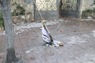 In Aleppo, Syria on January 10, 2026, a burned flag of the SDF (Syrian Democratic Forces) lies